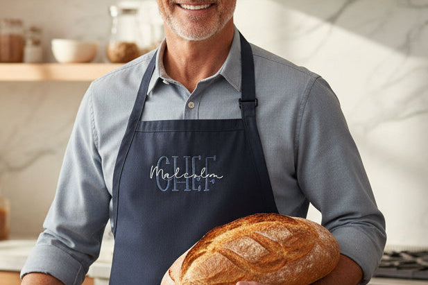Man holding a loaf of bread in a kitchen
