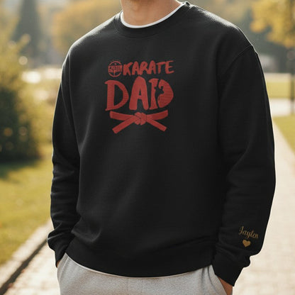 Man wearing a black 'Karate Dad' sweatshirt in a park setting